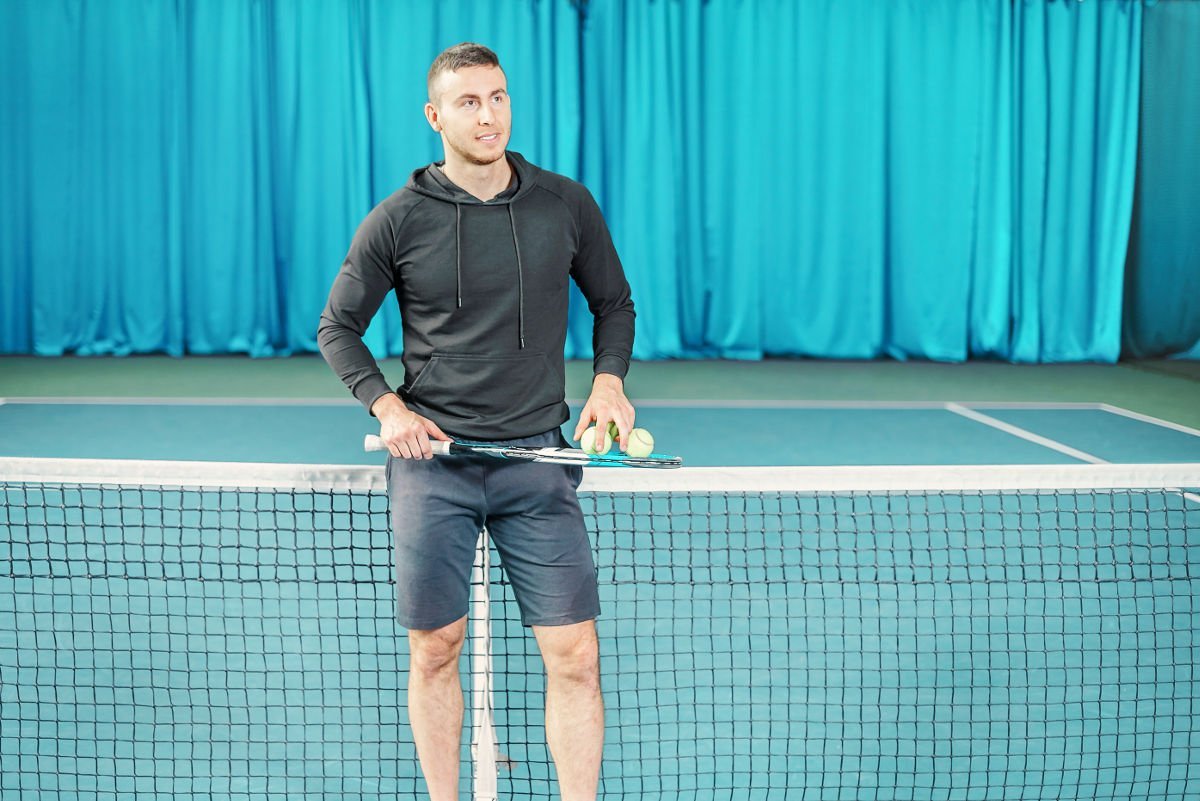 Foto de un jugador de tenis con una sudadera con capucha o un suéter