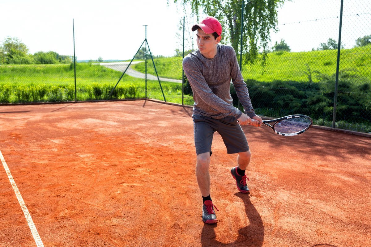 Foto di un giocatore di tennis con una maglia a maniche lunghe