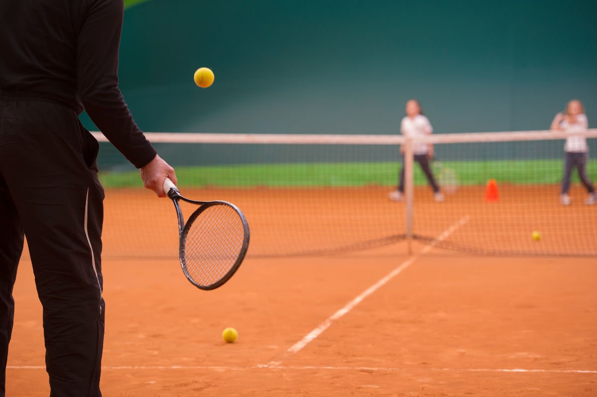 Foto di un allenatore di tennis con i pantaloni della tuta da ginnastica