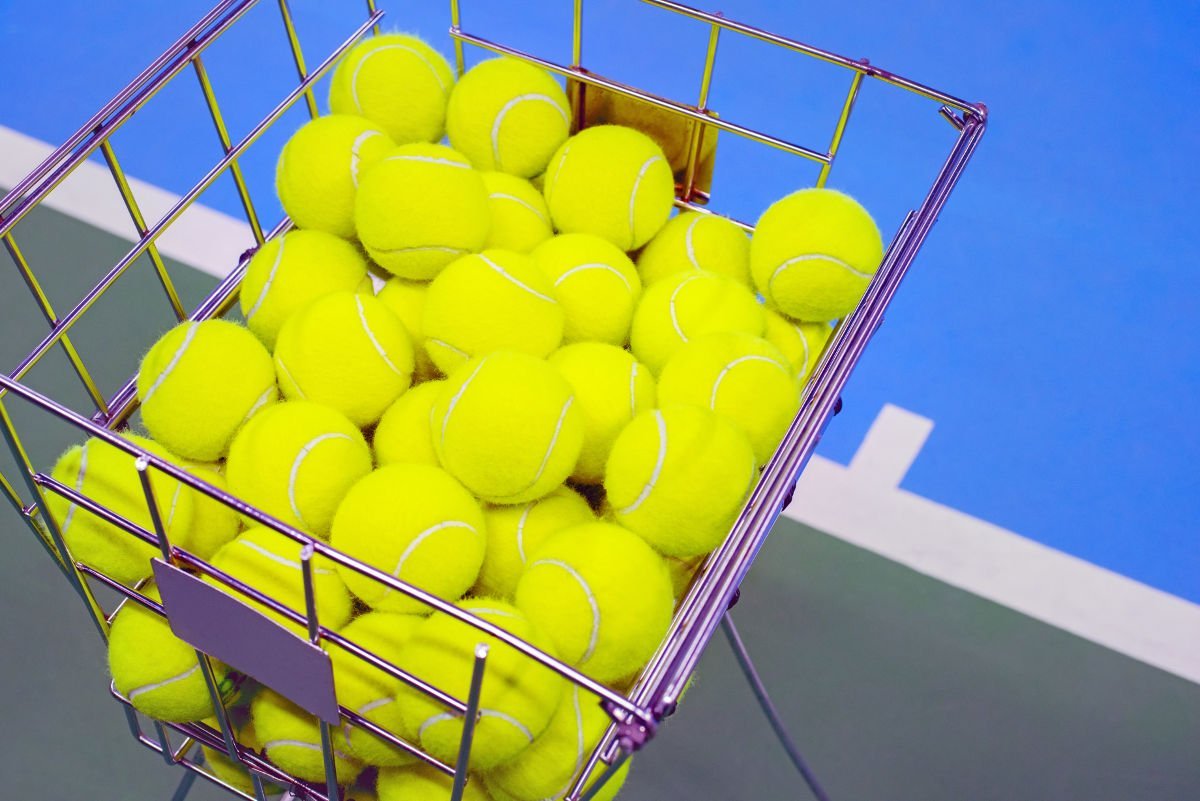 photo of several tennis balls in a ballhopper