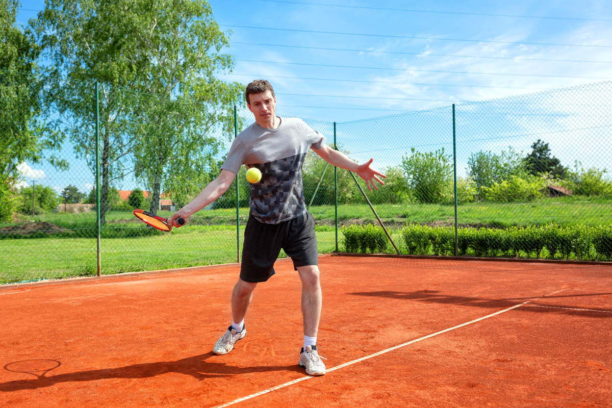 Foto van een tennisser bij de voorhand