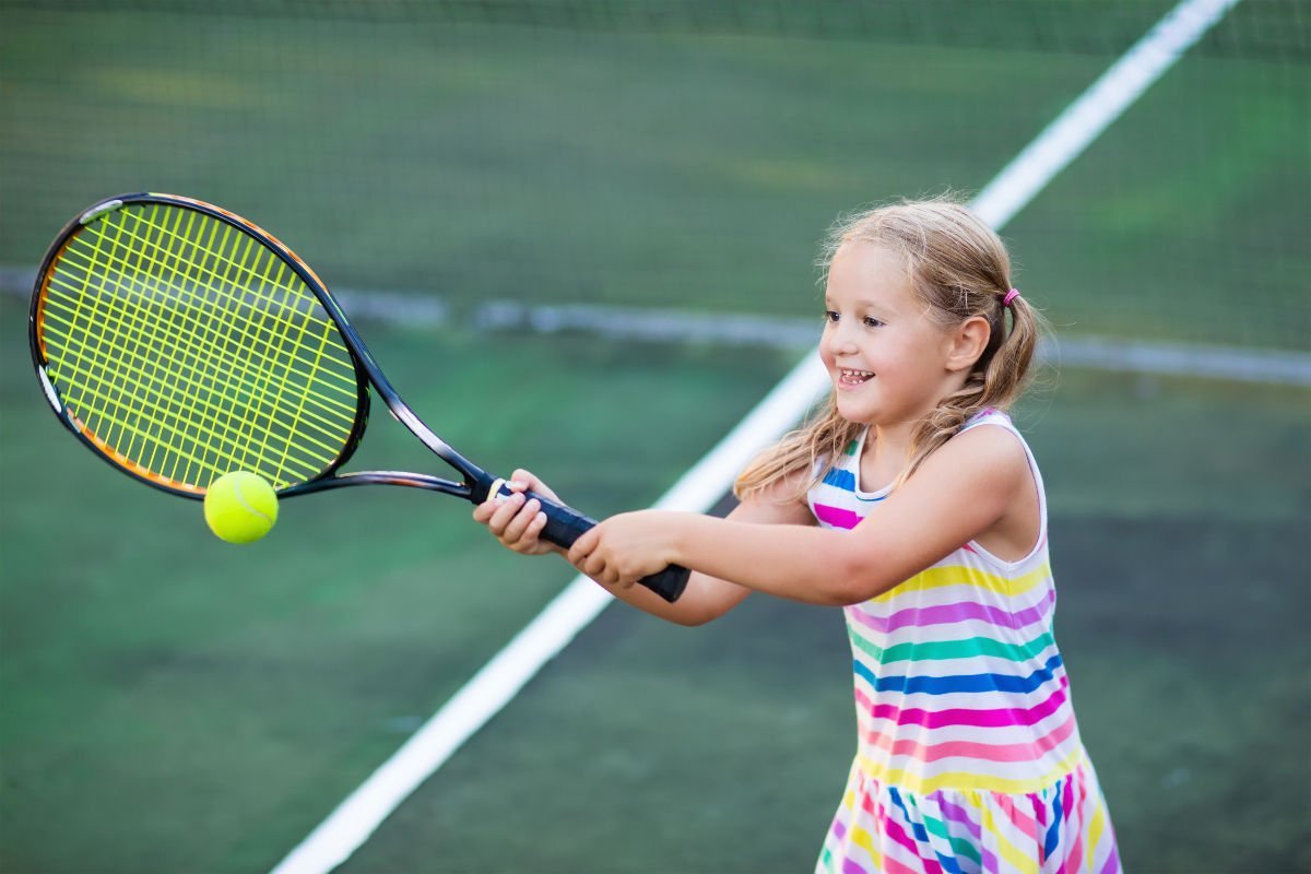 Foto van een kind met een tennisracket en een tennisjurk