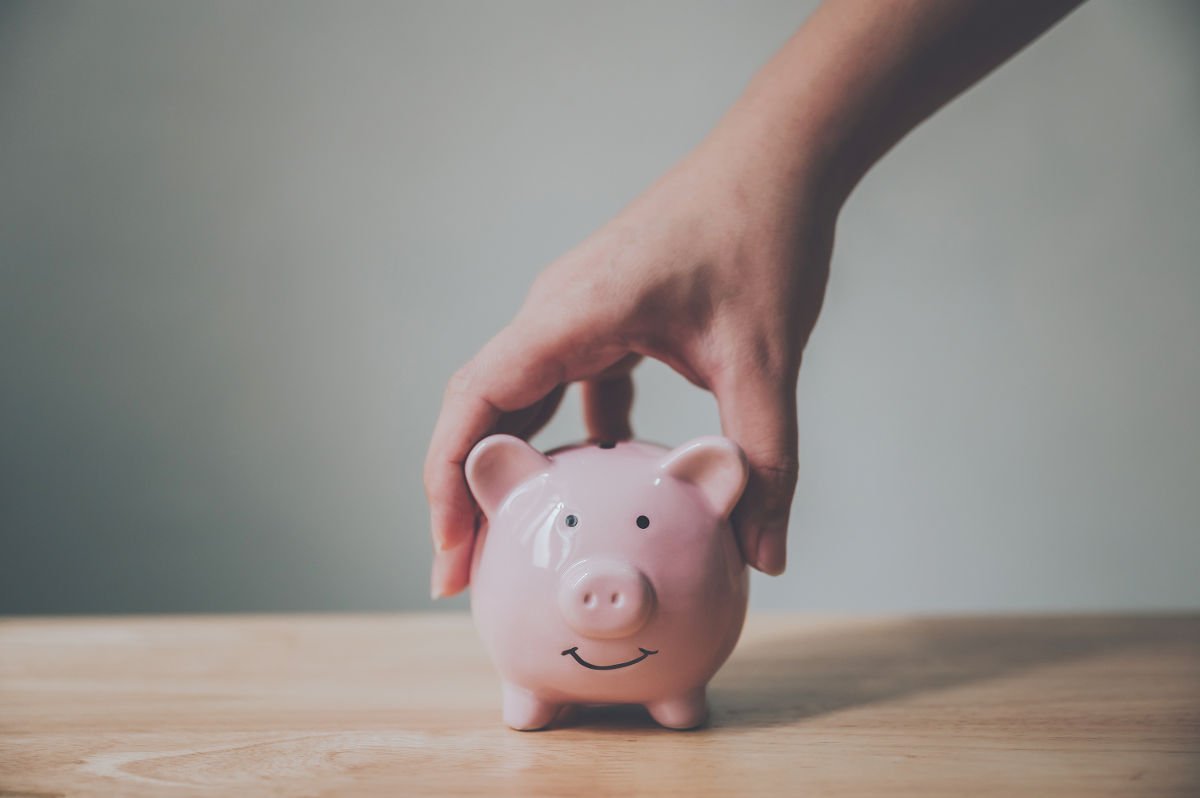 Foto einer Hand, die ein Sparschwein hält